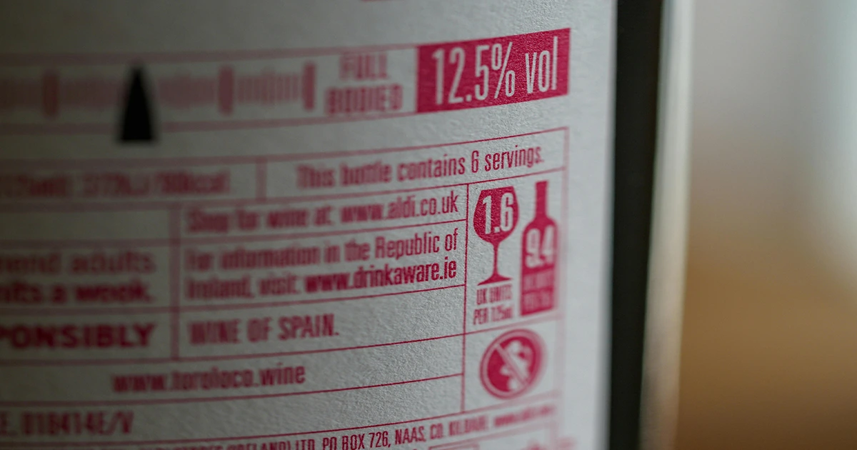 The text is displayed in red on a light background, emphasizing health-related warnings and serving information. The nutrition info panel provides essential consumption data for the product.